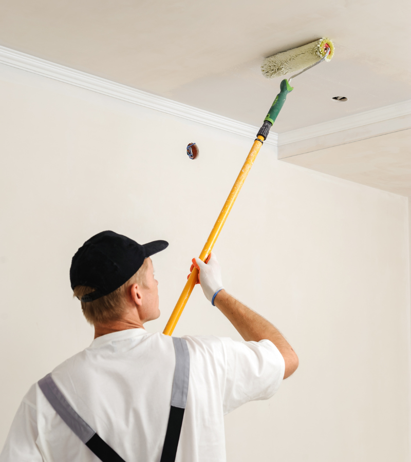 AIO Remodeling Solutions painting experts ensuring even coat on a residential wall.