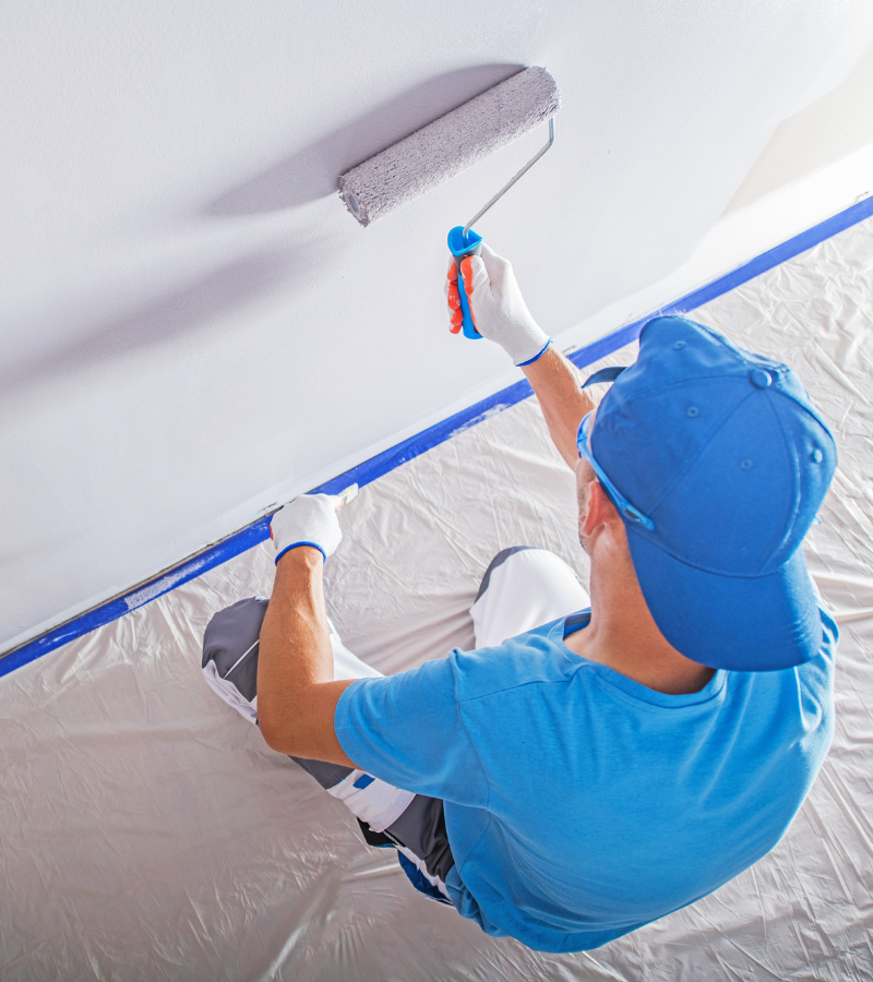 AIO Remodeling Solutions painting experts ensuring even coat on a residential wall.