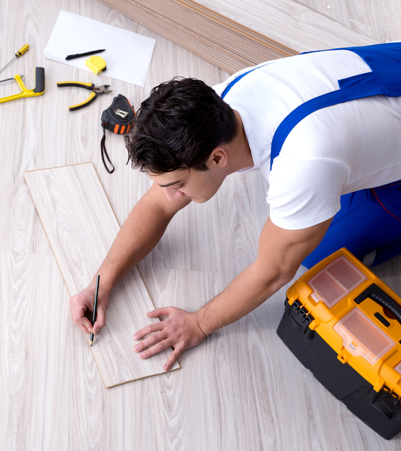 Expert AIO Remodeling Solutions worker fitting premium laminate flooring, call 425-891-0663 for service details.